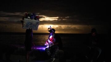 Vendedores ambulantes conversan en el Malec&oacute;n durante un apag&oacute;n en La Habana