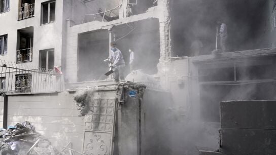 Voluntarios retiran los escombros en un edificio da&ntilde;ado por un ataque de Israel contra Teher&aacute;n (Ir&aacute;n)