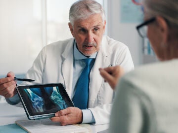 M&eacute;dico experto hablando con paciente de sus huesos