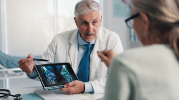 M&eacute;dico experto hablando con paciente de sus huesos