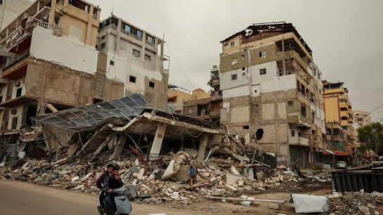 Unos hombres pasan en scooter junto a los escombros de un edificio destruido por un ataque israel&iacute;, en Tiro, L&iacute;bano, el 2 de abril de 2026.