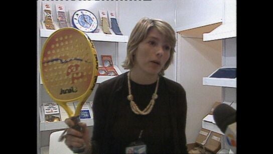 Una empleada enseña una pala de pádel con el logo del PP