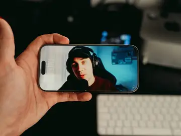 Una persona viendo a un creador de contenido en el móvil Una persona viendo a un creador de contenido en el móvil