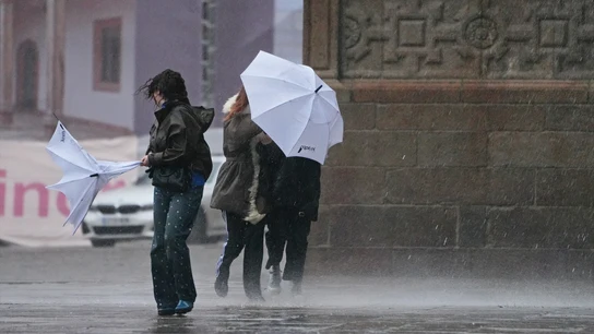 Varias personas intentan sujetar sus paraguas en Santiago de Compostela, Galicia. Varias personas intentan sujetar sus paraguas en Santiago de Compostela, Galicia.