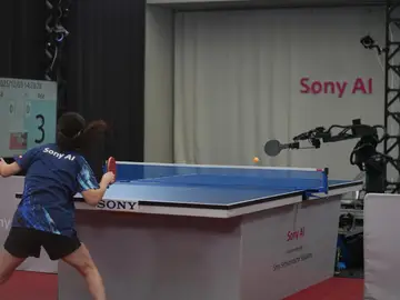 Una jugadora de ping-pong compitiendo contra el robot Ace Una jugadora de ping-pong compitiendo contra el robot Ace