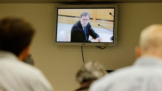 Una pantalla en la sala de prensa muestra al expresidente del Gobierno Mariano Rajoy durante su declaraci&oacute;n como testigo en el juicio del caso Kitchen.
