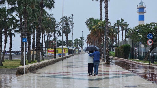 Dos personas pasean bajo un paraguas