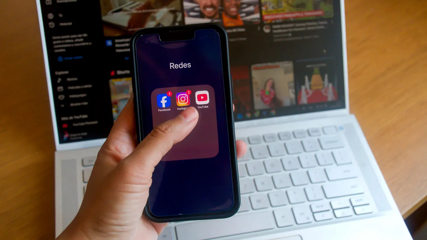 Una persona con un móvil donde se ven logos de varias redes sociales. Una persona con un móvil donde se ven logos de varias redes sociales.