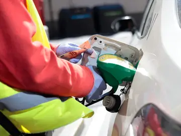Un empleado de una estación de servicio llenando el depósito de un coche en Madrid Un empleado de una estación de servicio llenando el depósito de un coche en Madrid