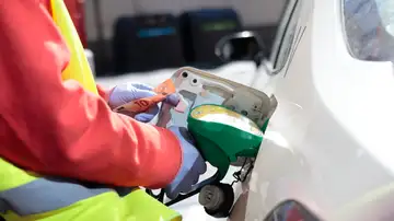 Un empleado de una estación de servicio llenando el depósito de un coche en Madrid Un empleado de una estación de servicio llenando el depósito de un coche en Madrid