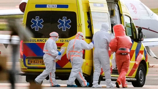 Personal m&eacute;dico acompa&ntilde;a a un paciente, segundo por la derecha, evacuado del crucero MV Hondius 
