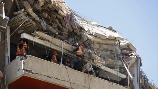 Operarios trabajan para retirar los escombros en un edificio al sur de Beirut