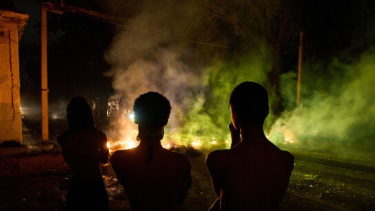 Varias personas observan una barricada levantada por residentes que protestan contra los prolongados cortes de electricidad en La Habana, Cuba
