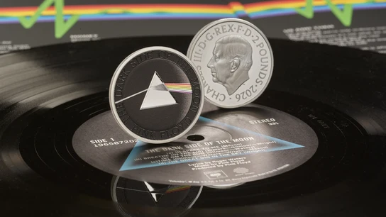 La moneda conmemorativa oficial de Pink Floyd acuñada por la Real Casa de la Moneda, con el icónico diseño del prisma de The Dark Side of the Moon en el reverso y el retrato del rey en el anverso. La moneda conmemorativa oficial de Pink Floyd acuñada por la Real Casa de la Moneda, con el icónico diseño del prisma de The Dark Side of the Moon en el reverso y el retrato del rey en el anverso.