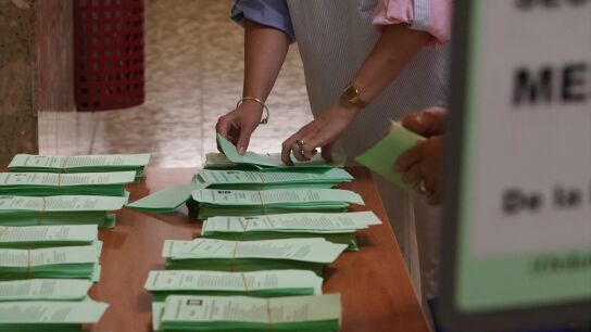 Una persona coge una papeleta en la jornada electoral en Andaluc&iacute;a.