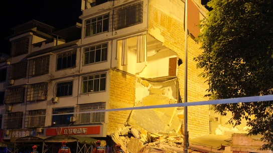 Los equipos de rescate caminan junto a un edificio dañado tras un terremoto en la aldea de Taiyang, en Liuzhou Los equipos de rescate caminan junto a un edificio dañado tras un terremoto en la aldea de Taiyang, en Liuzhou