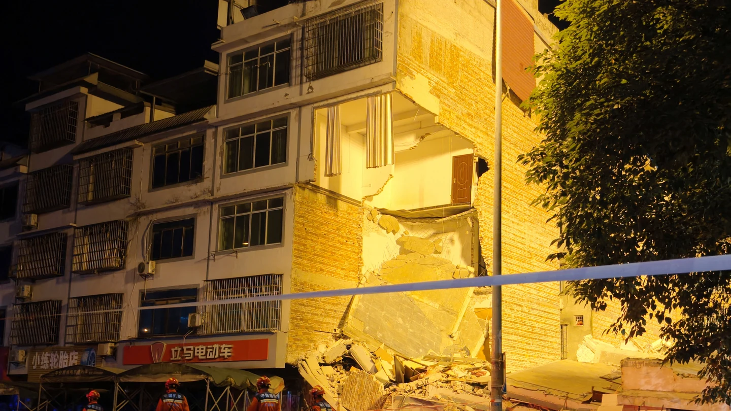 Los equipos de rescate caminan junto a un edificio dañado tras un terremoto en la aldea de Taiyang, en Liuzhou Los equipos de rescate caminan junto a un edificio dañado tras un terremoto en la aldea de Taiyang, en Liuzhou