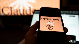 Una persona sostiene un tel&eacute;fono con el logotipo de la inteligencia artificial (IA) Anthropic