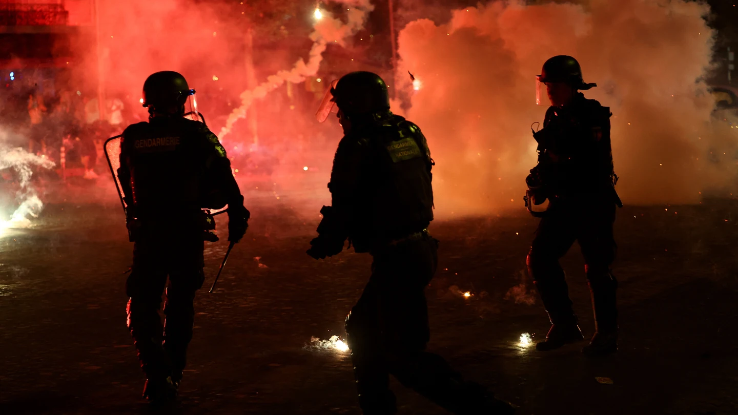 Agentes de policía se protegen de las bengalas tras la victoria del Paris Saint-Germain en la Liga de Campeones de la UEFA. Agentes de policía se protegen de las bengalas tras la victoria del Paris Saint-Germain en la Liga de Campeones de la UEFA.