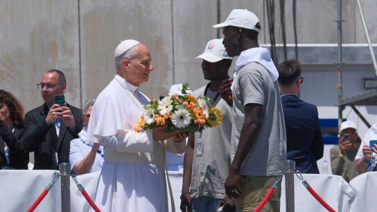 El papa Le&oacute;n XIV recibe flores de dos voluntarios en el muelle de Arguinegu&iacute;n, en Gran Canaria/ EFE/ Angel Medina G. POOL
