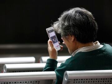 Un hombre mirando su m&oacute;vil