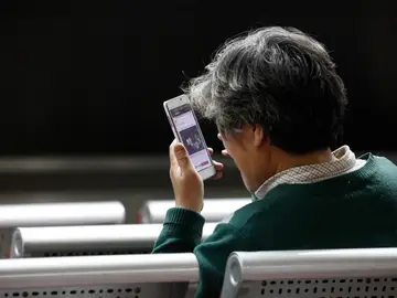 Un hombre mirando su móvil Un hombre mirando su móvil