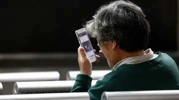 Un hombre mirando su móvil Un hombre mirando su móvil