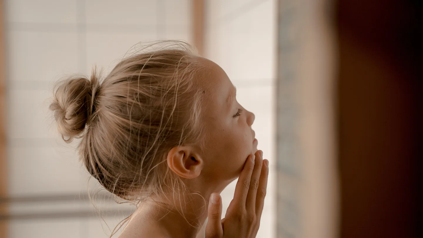Una niña dándose una crema Una niña dándose una crema