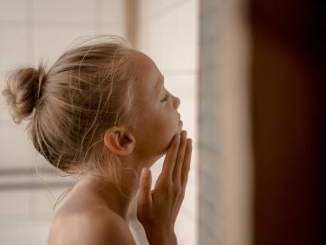 Una niña dándose una crema Una niña dándose una crema