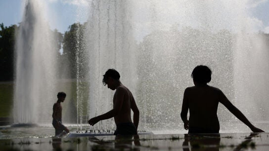Ni&ntilde;os se refrescan en la fuente del Trocadero, junto a la Torre Eiffel en Par&iacute;s