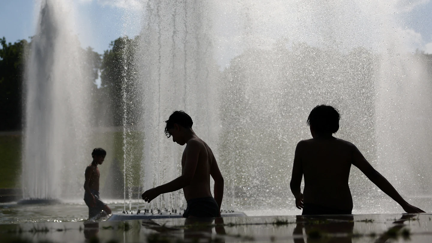 Niños se refrescan en la fuente del Trocadero, junto a la Torre Eiffel en París Niños se refrescan en la fuente del Trocadero, junto a la Torre Eiffel en París