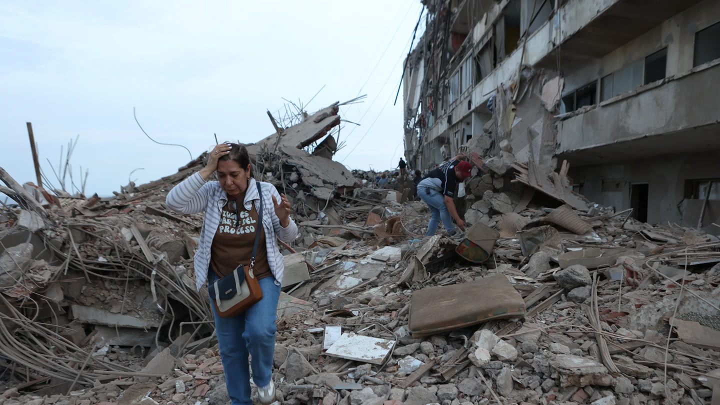 Una mujer camina entre los escombros de un edificio derrumbado por los terremotos en Venezuela Una mujer camina entre los escombros de un edificio derrumbado por los terremotos en Venezuela