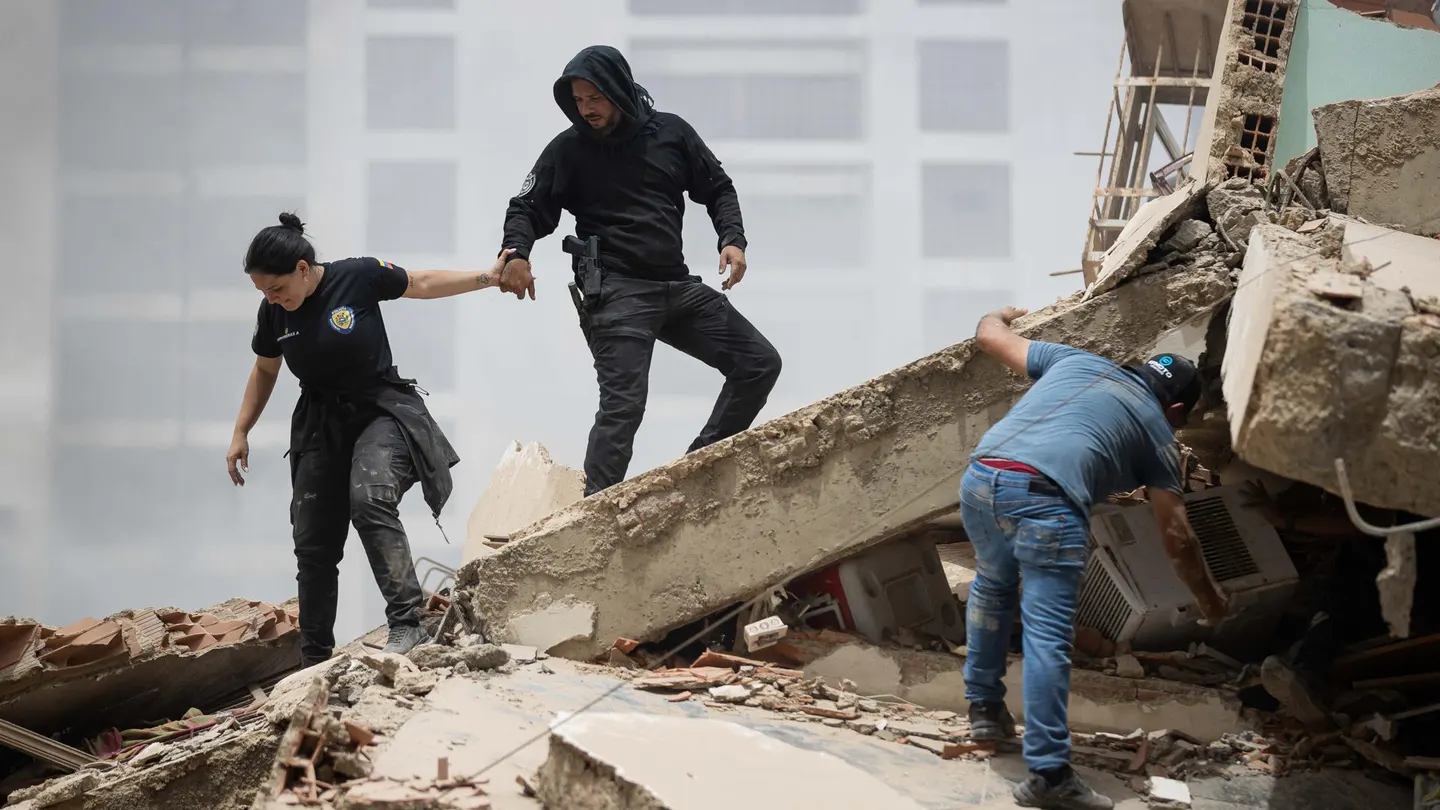 Personas caminan entre escombros de edificios derrumbados este jueves, en La Guaira. Personas caminan entre escombros de edificios derrumbados este jueves, en La Guaira.