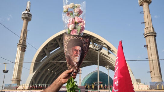Un hombre sostiene una imagen del asesinado l&iacute;der supremo de Ir&aacute;n Al&iacute; Jamene&iacute; durante el funeral del religioso