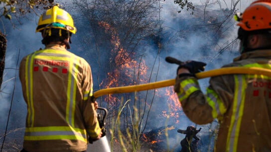 Bomberos trabajan en uno de los focos del incendio en la localidad de Calonge este s&aacute;bado tras el incendio forestal que comenz&oacute; este viernes en La Bisbal de l'Empord&agrave; (Girona).