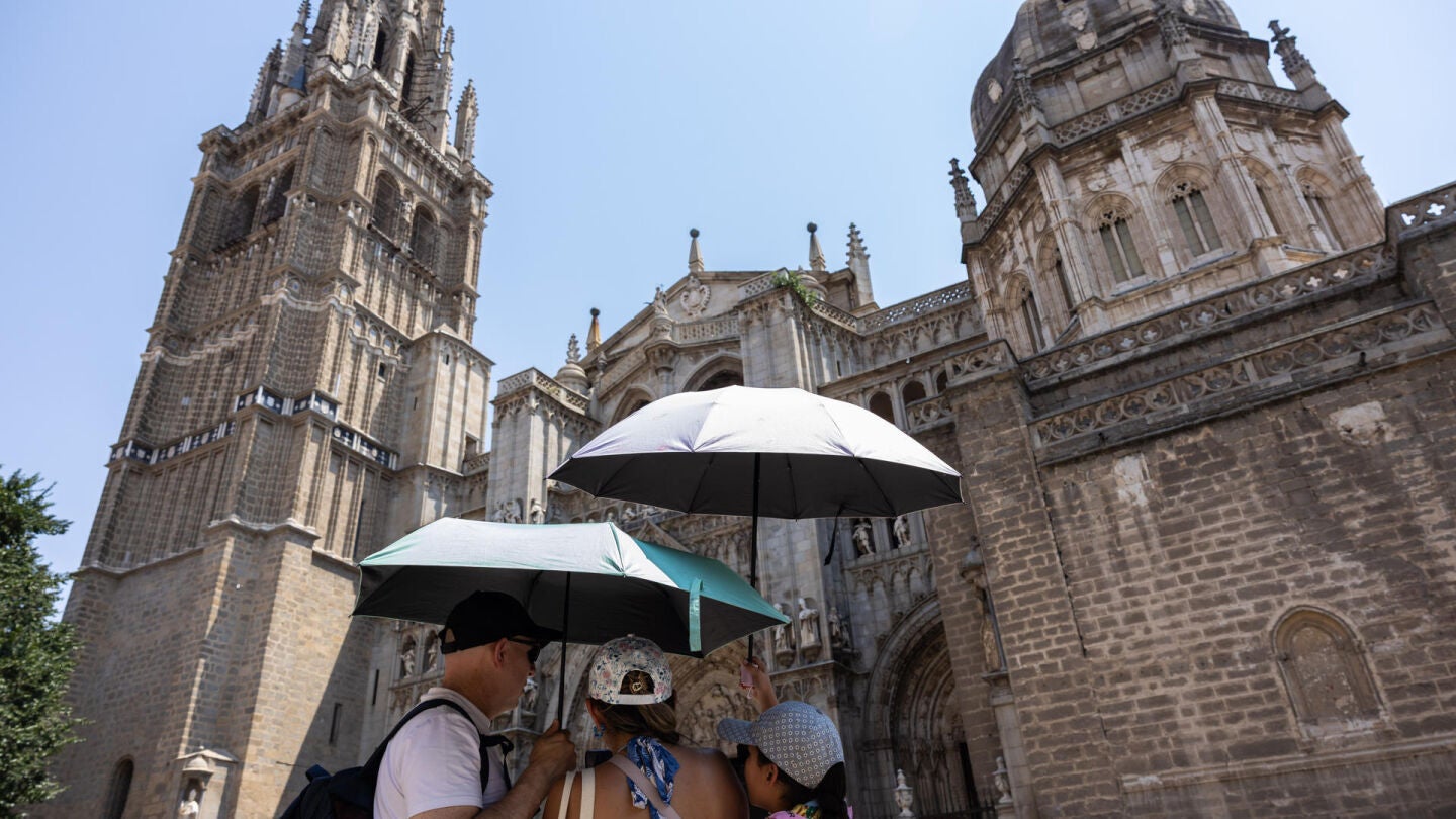  Varias personas se protegen del sol este martes en Toledo.