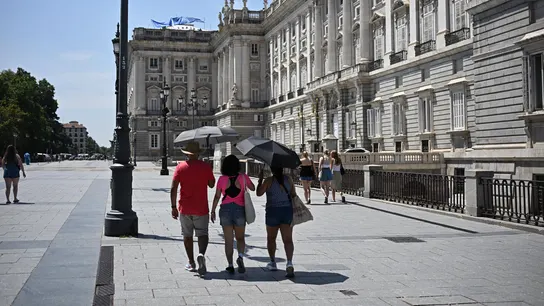 Imagen de archivo. Varias personas protegiéndose del sol frente al Palacio Real en Madrid. Imagen de archivo. Varias personas protegiéndose del sol frente al Palacio Real en Madrid.