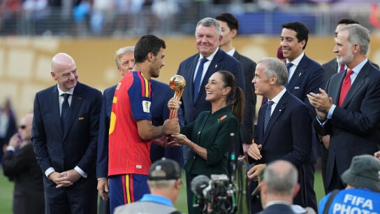 Rodri Hern&aacute;ndez (ci) de Espa&ntilde;a recibe el trofeo del Bal&oacute;n de Oro de manos de la presidenta de M&eacute;xico, Claudia Sheinbaum el 19 de julio de 2026, en el estadio MetLife en Nueva Jersey.