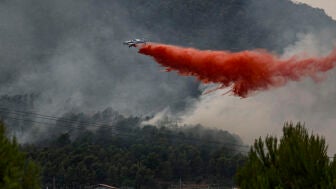 Un avi&oacute;n realiza una descarga con retardante en Betx&iacute; en el frente del incendio declarado este s&aacute;bado en la Vall d'Uix&oacute;