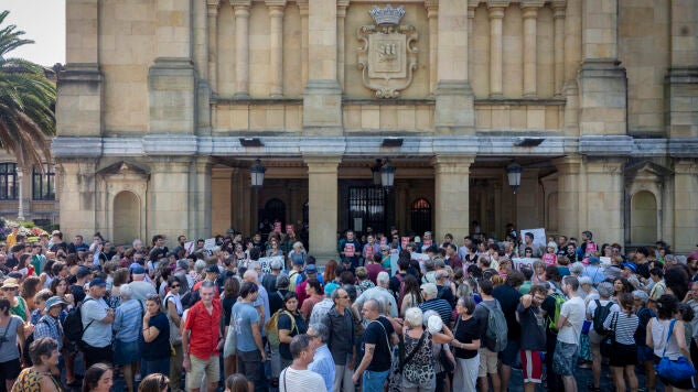 Miembros de la asociaci&oacute;n Kaleko Afari Solidarioak (Cenas solidarias callejeras) protestan frente al consistorio este martes, tras la prohibici&oacute;n por parte del Ayuntamiento de San Sebasti&aacute;n de las denominadas 'cenas solidarias', 