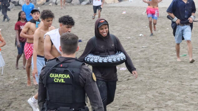 Un grupo de inmigrantes en la playa junto al paso fronterizo del Tarajal en Ceuta.