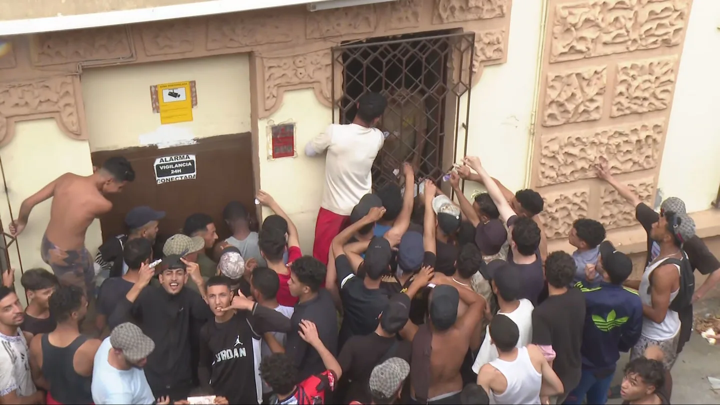 Decenas de migrantes, ante un comercio cerrado Decenas de migrantes, ante un comercio cerrado