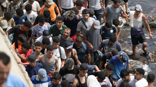 Varias personas caminan por la playa tras intentar cruzar desde la localidad marroqu&iacute; de Fnideq, situada al norte del pa&iacute;s, hasta Ceuta. 