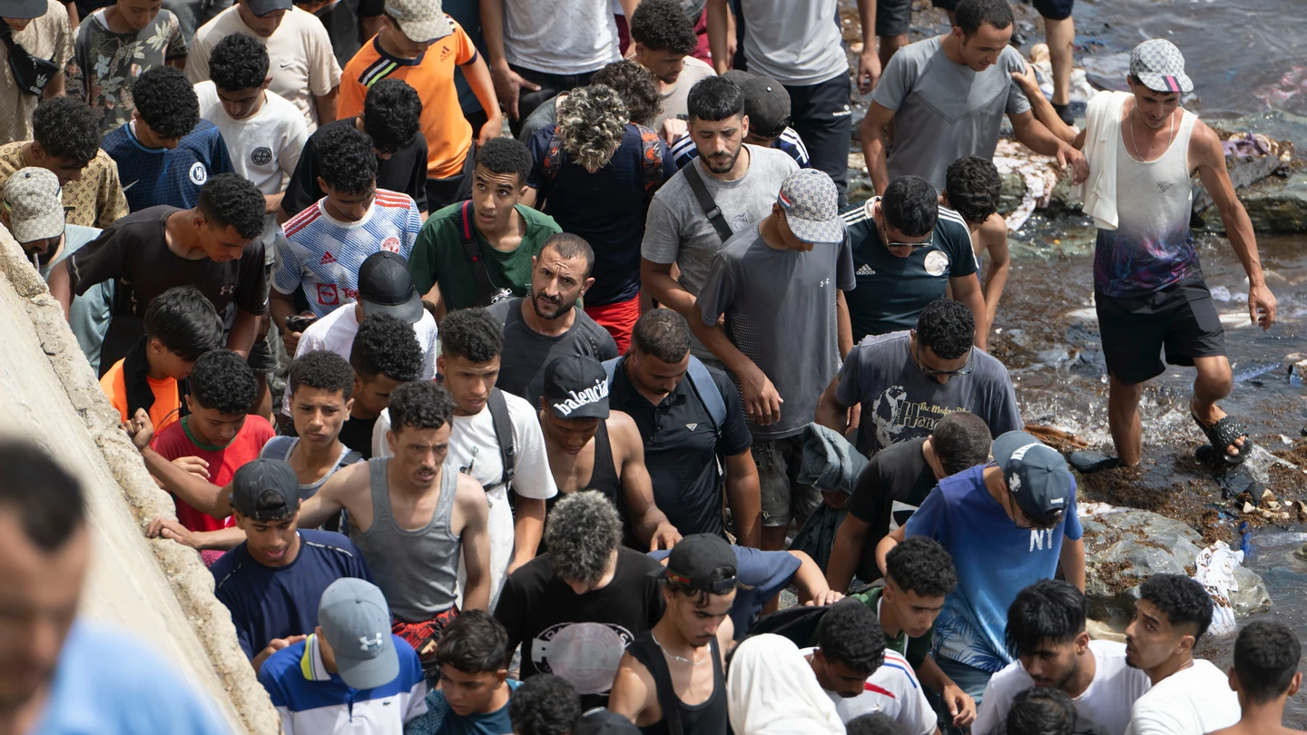 Varias personas caminan por la playa tras intentar cruzar desde la localidad marroquí de Fnideq, situada al norte del país, hasta Ceuta. Varias personas caminan por la playa tras intentar cruzar desde la localidad marroquí de Fnideq, situada al norte del país, hasta Ceuta.
