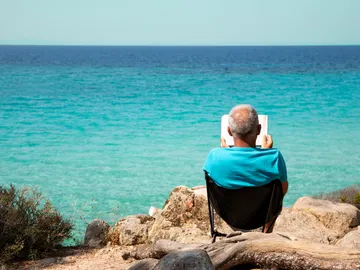 Persona leyendo junto al mar Persona leyendo junto al mar