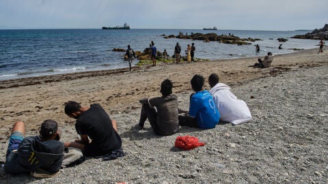 Los migrantes que han cruzado a Espa&ntilde;a desde Marruecos se concentran en una playa de Ceuta. 
