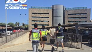 El detenido, de espaldas y escoltado por tres agentes de la Polic&iacute;a Nacional