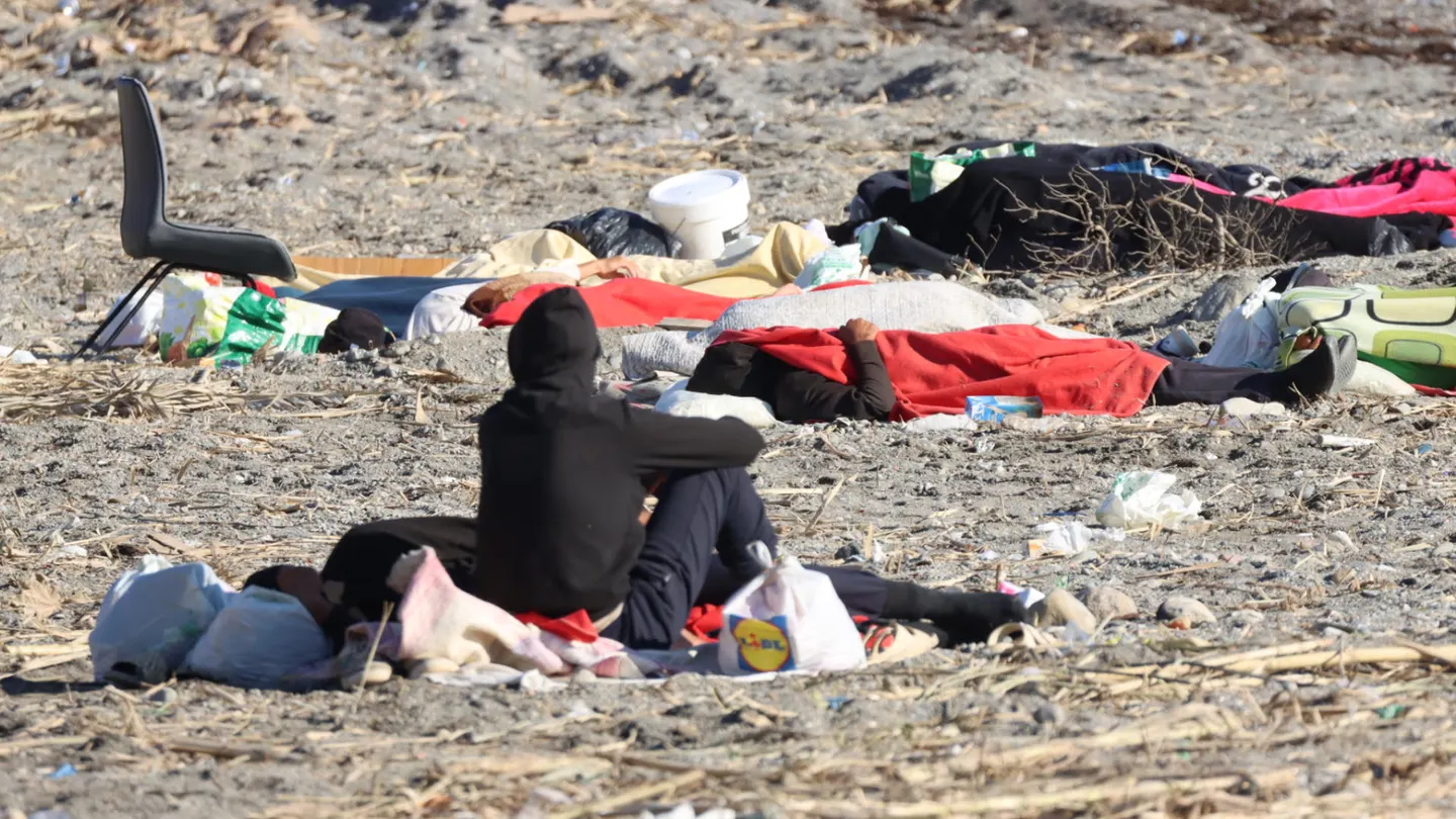Varios migrantes en la playa de El Trampolín, de Ceuta, este sábado. Varios migrantes en la playa de El Trampolín, de Ceuta, este sábado.