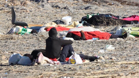 Varios migrantes en la playa de El Trampol&iacute;n, de Ceuta, este s&aacute;bado.