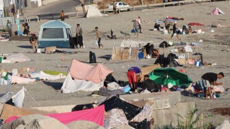 Varios migrantes permanecen este lunes acampados en la playa de El Trampol&iacute;n de Ceuta. 